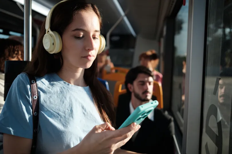 Une personne écoute au casque dans les transports en commun.