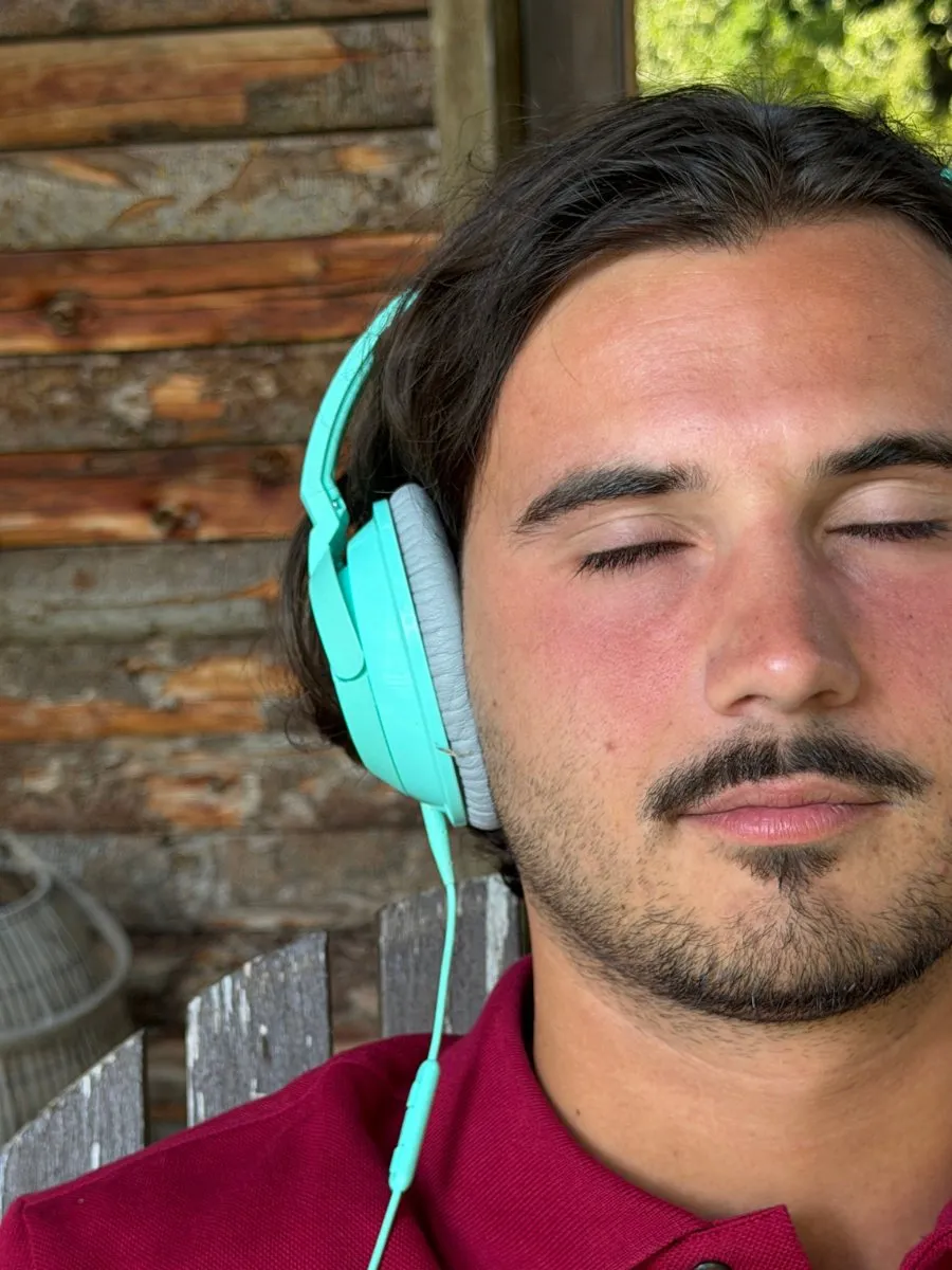 Un étudiant au casque, les yeux fermés, concentré.